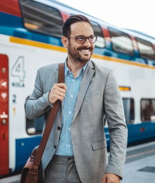 Mann am Bahnhof vor einem Zug